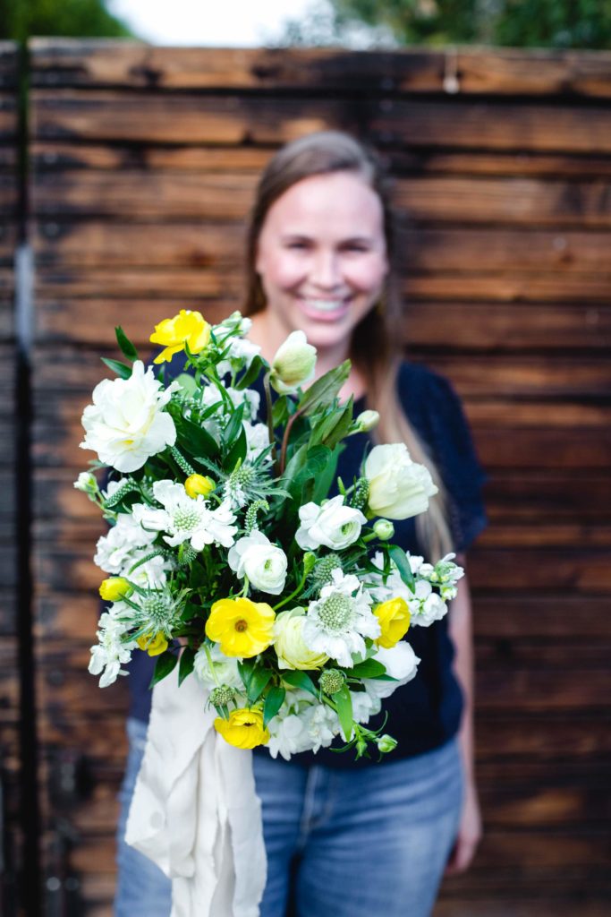 Organic greenery bouquet with white and yellow wildflowers.