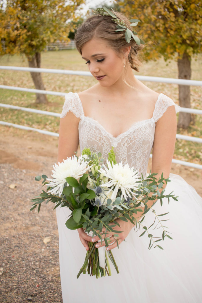 Bride with bouquet and hair floral at winter neutral palette wedding with taupe and blush accents featuring white flowers with greenery by Array Design, Phoenix, Arizona.
