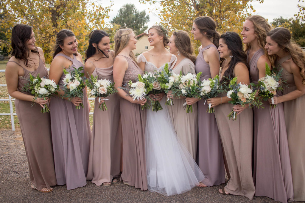 Bride and bridesmaids with bouquets at winter neutral palette wedding with taupe and blush accents featuring white flowers with greenery by Array Design, Phoenix, Arizona.