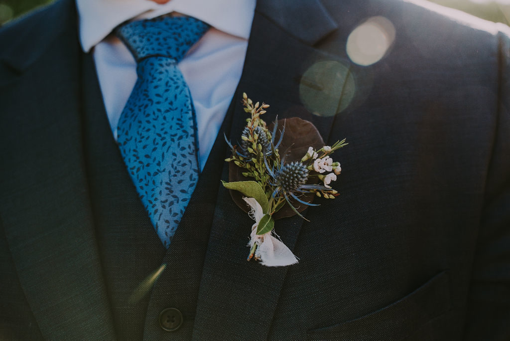 Boutonnière at Arizona early fall wedding featuring peachy gold palette at Gather Estate, Mesa. Floral by Array Design, Phoenix, Arizona.