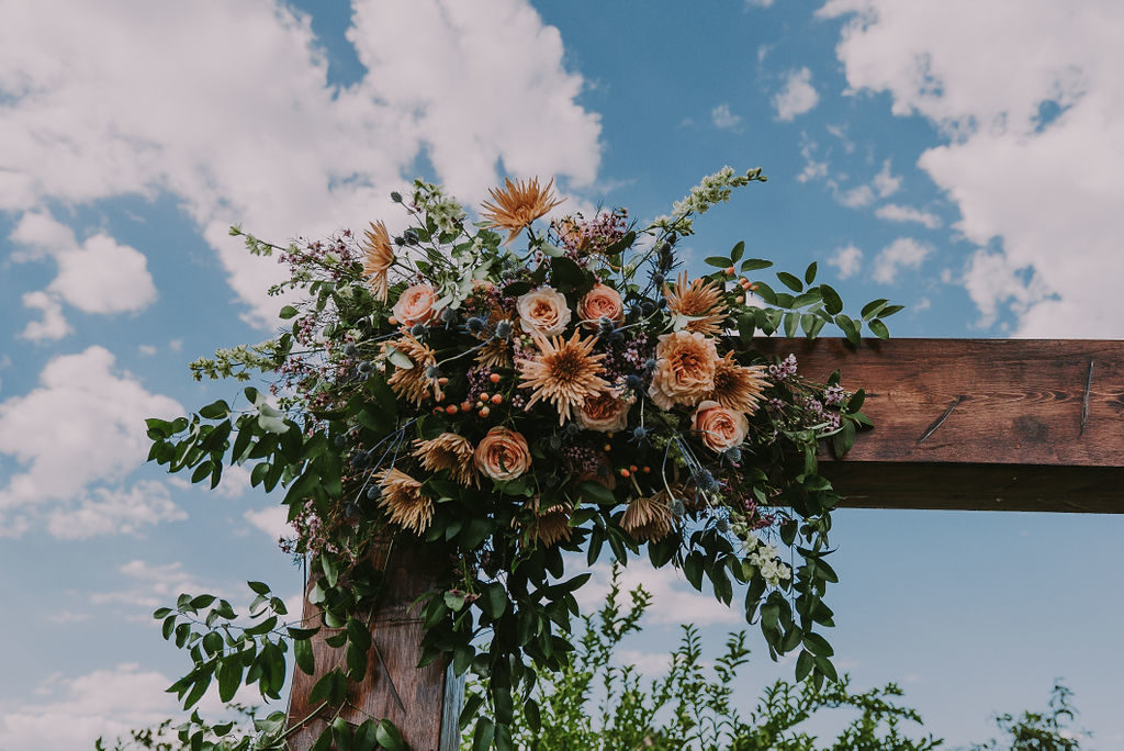 Arch floral at Arizona early fall wedding featuring peachy gold palette at Gather Estate, Mesa. Floral by Array Design, Phoenix, Arizona.