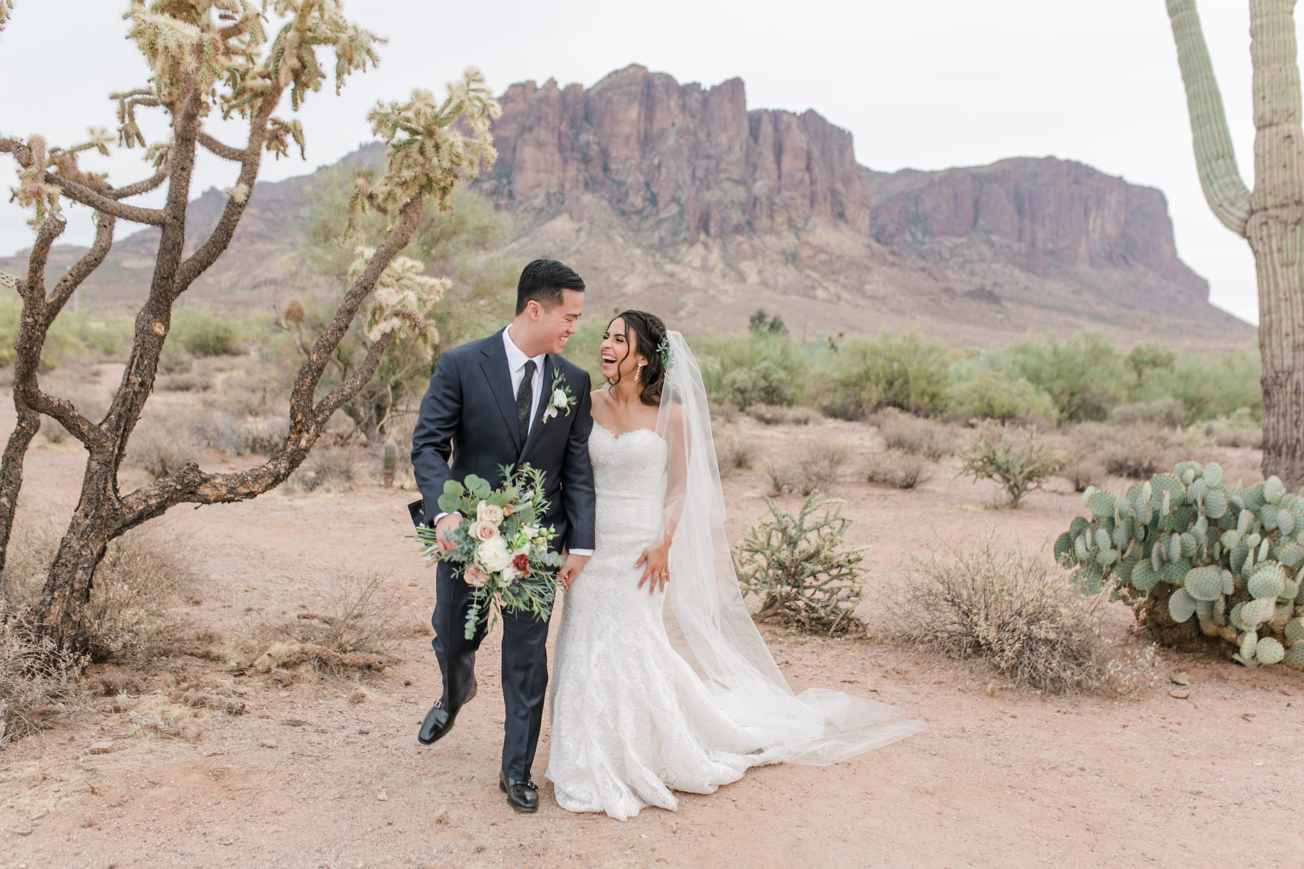 bride and groom walking in desert