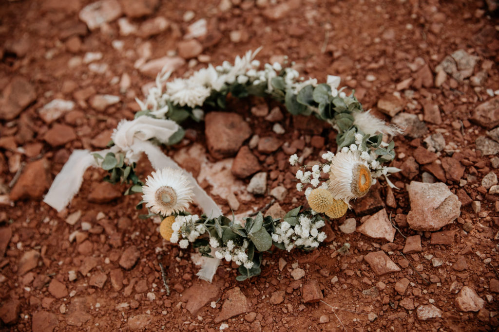 Arizona wedding elopement at Castle Rock in Sedona. Boho style designs made this celebration the couple's own. Floral arrangements of a bridal bouquet and flower crown honor the rich desert colors.