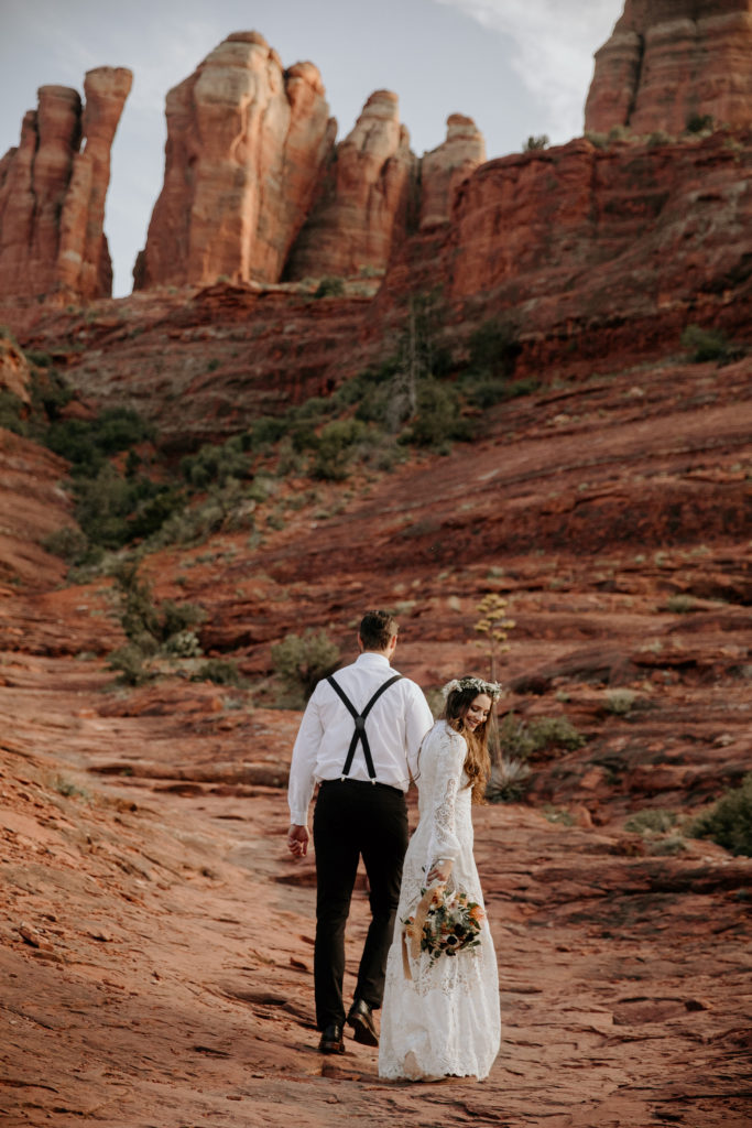 Arizona wedding elopement at Castle Rock in Sedona. Boho style designs made this celebration the couple's own. Floral arrangements of a bridal bouquet and flower crown honor the rich desert colors.