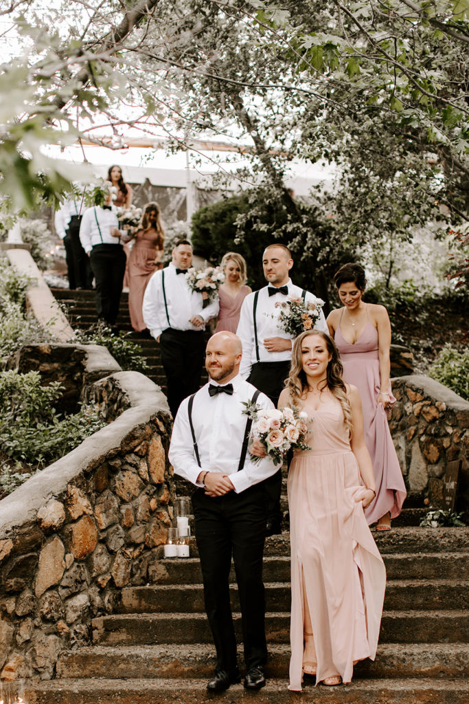 Romantic Southern California mountain wedding at Sacred Mountain Julian. Beautiful blush wedding flowers with complimenting white in bridal and bridesmaid bouquets with greenery throughout the celebration.