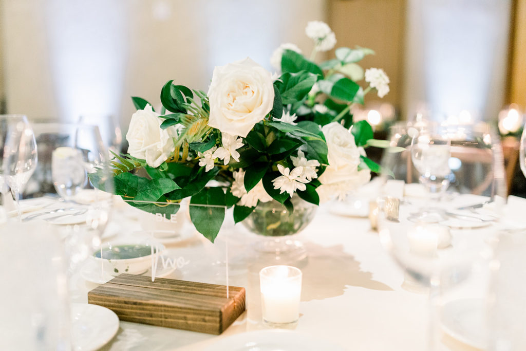 White floral reception centerpiece at Arizona wedding Phoenix venue, Royal Palms. Stylish celebration featuring white wedding flowers and greenery with pillar candles featured in reception and ceremony. Floral arrangements by Array Design. Photography by Jessica Q.