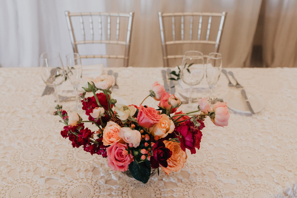 Reception sweetheart table at bougainvillea inspired Arizona wedding with bright floral arrangements and mountain views at this desert wedding. Wedding flowers by Array Design, Phoenix, Arizona. Photographer Kristen Hennke.