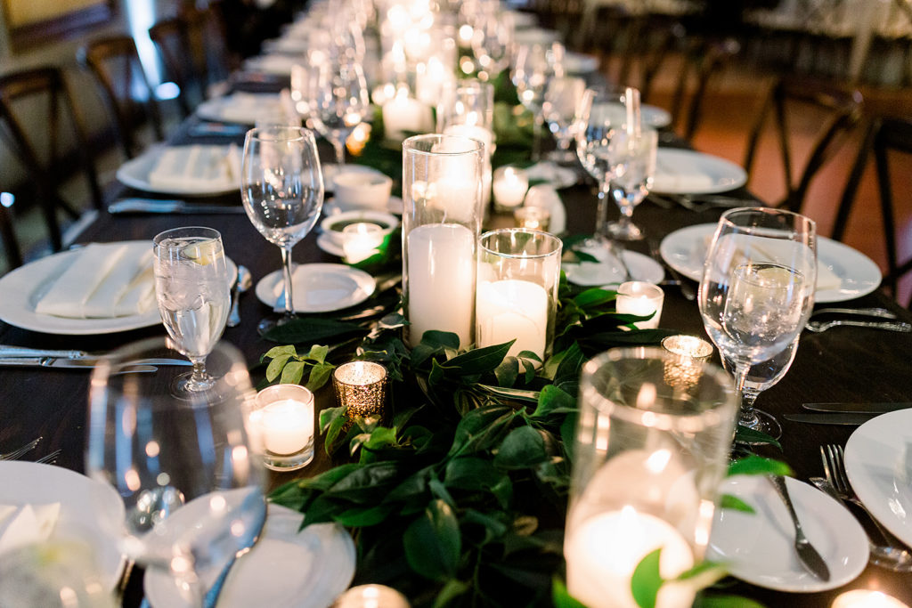 Reception table greenery at Arizona wedding Phoenix venue, Royal Palms. Stylish celebration featuring white wedding flowers and greenery with pillar candles featured in reception and ceremony. Floral arrangements by Array Design. Photography by Jessica Q.