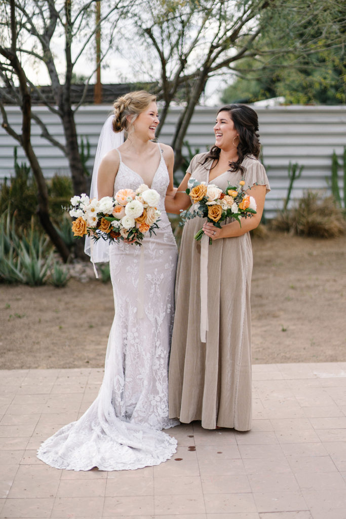 Arizona Modern Spring Wedding - the perfect taupe bridesmaid dress at an elegant and modern urban wedding at The Venue on Washington in Phoenix. The gold wedding flowers with peach and white in the wedding color palette was seen in the wedding flower arrangements, bridal bouquet, bridesmaid bouquets, boutonniere, and bud vases of gold roses. The spring wedding flowers included roses, ranunculus, blue thistle, and greenery. Photos by Emily B. #wedding #springwedding #weddingflowers