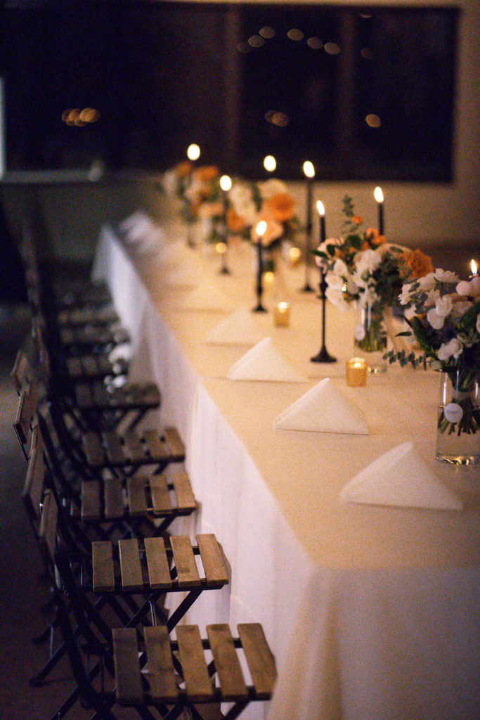Arizona Modern Spring Wedding - the perfect candlelit reception at an elegant and modern urban wedding at The Venue on Washington in Phoenix. The gold wedding flowers with peach and white in the wedding color palette was seen in the wedding flower arrangements, bridal bouquet, bridesmaid bouquets, boutonniere, and bud vases of gold roses. The spring wedding flowers included roses, ranunculus, blue thistle, and greenery. Photos by Emily B. #wedding #springwedding #weddingflowers