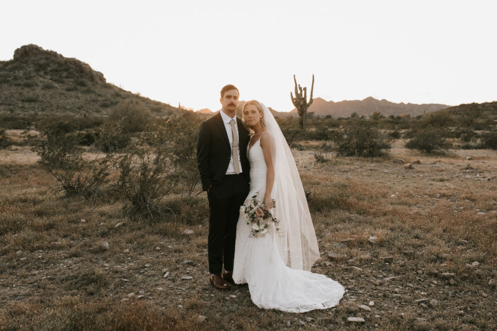Boho Arizona Desert Ceremony - the perfect intimate desert wedding ceremony. The blush and white wedding flowers with dusty pink wedding color palette was seen in the wedding flower arrangements, ceremony decor, wedding bouquets, wedding ceremony backdrop outdoor, and wedding flowers. The boho wedding flowers included pampas grass, roses and greenery. Wedding ceremony altar of pampas grass, roses and greenery. Photos by Madi Robison. #weddingbouquets #desertwedding #weddingflowers #weddings