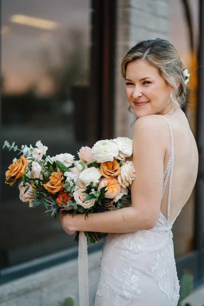 Arizona Modern Spring Wedding - the loveliest bride at an elegant and modern urban wedding at The Venue on Washington in Phoenix. The gold wedding flowers with peach and white in the wedding color palette was seen in the wedding flower arrangements, bridal bouquet, bridesmaid bouquets, boutonniere, and bud vases of gold roses. The spring wedding flowers included roses, ranunculus, blue thistle, and greenery. Photos by Emily B. #wedding #springwedding #weddingflowers