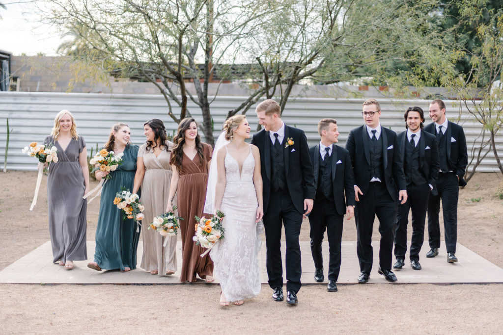 Arizona Modern Spring Wedding - the loveliest bridal party at an elegant and modern urban wedding at The Venue on Washington in Phoenix. The gold wedding flowers with peach and white in the wedding color palette was seen in the wedding flower arrangements, bridal bouquet, bridesmaid bouquets, boutonniere, and bud vases of gold roses. The spring wedding flowers included roses, ranunculus, blue thistle, and greenery. Photos by Emily B. #wedding #springwedding #weddingflowers