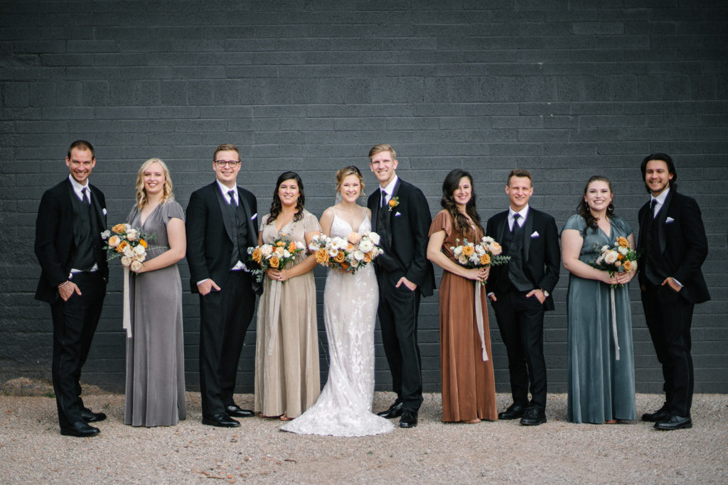 Arizona Modern Spring Wedding - the perfect crushed velvet bridesmaid dresses at an elegant and modern urban wedding at The Venue on Washington in Phoenix. The gold wedding flowers with peach and white in the wedding color palette was seen in the wedding flower arrangements, bridal bouquet, bridesmaid bouquets, boutonniere, and bud vases of gold roses. The spring wedding flowers included roses, ranunculus, blue thistle, and greenery. Photos by Emily B. #wedding #springwedding #weddingflowers