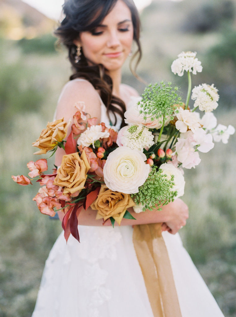 Romantic Arizona Bridal Shoot - the perfect organic bridal bouquet for an Arizona bride and groom desert wedding. The colorful wedding color palette was seen in the bridal bouquet of white, gold, peach, red and blush wedding flowers. The spring wedding flowers included ranunculus, sweet peas, and scabiosa flowers at the Phoenix bridal shoot. Photos by MaryClaire.
#weddingbouquets #springwedding #weddingflowers #arizonawedding