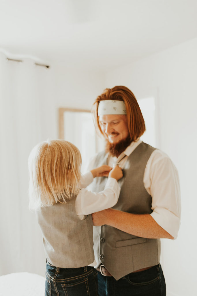 Young boy straightening father's tie.