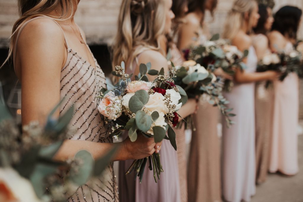 Bridesmaids holding their bouquets during wedding ceremony.