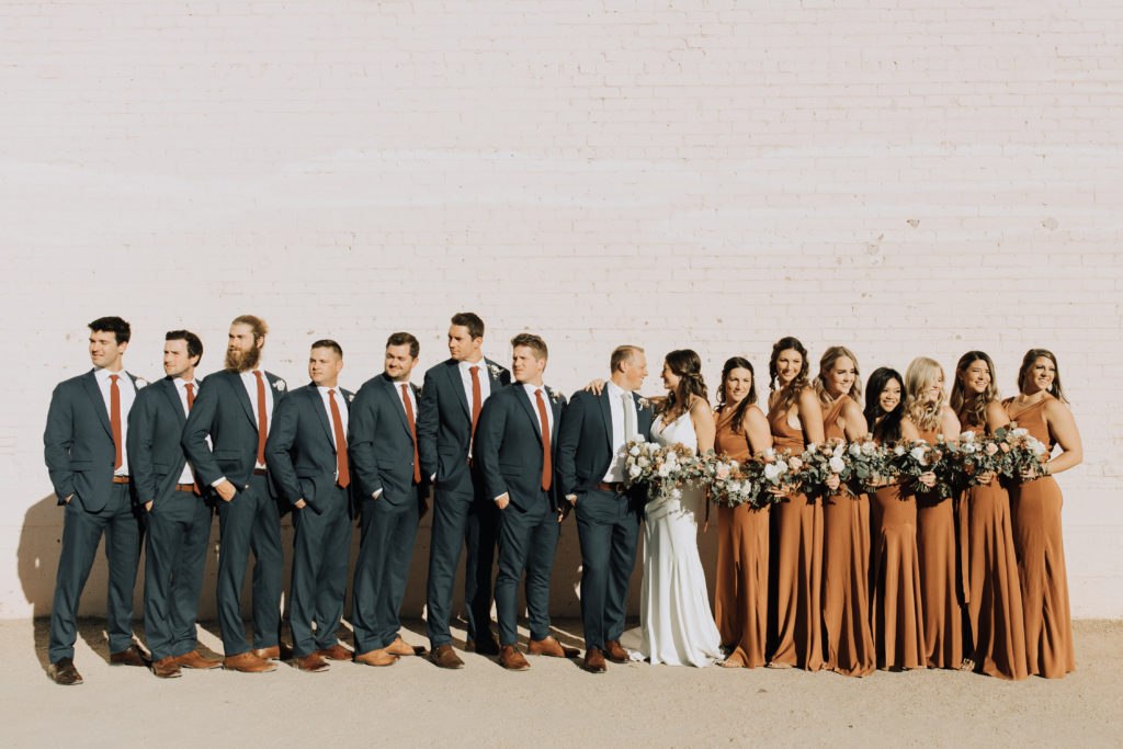 Large wedding party with groomsmen and bridesmaids.