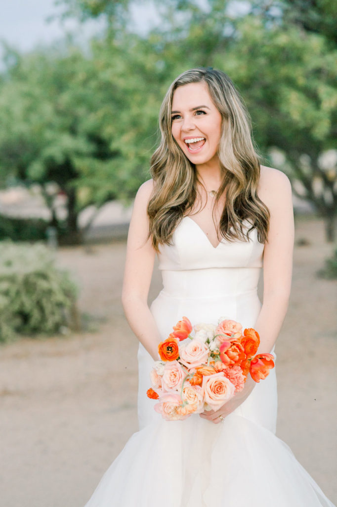 Bride smiling holding bouquet.