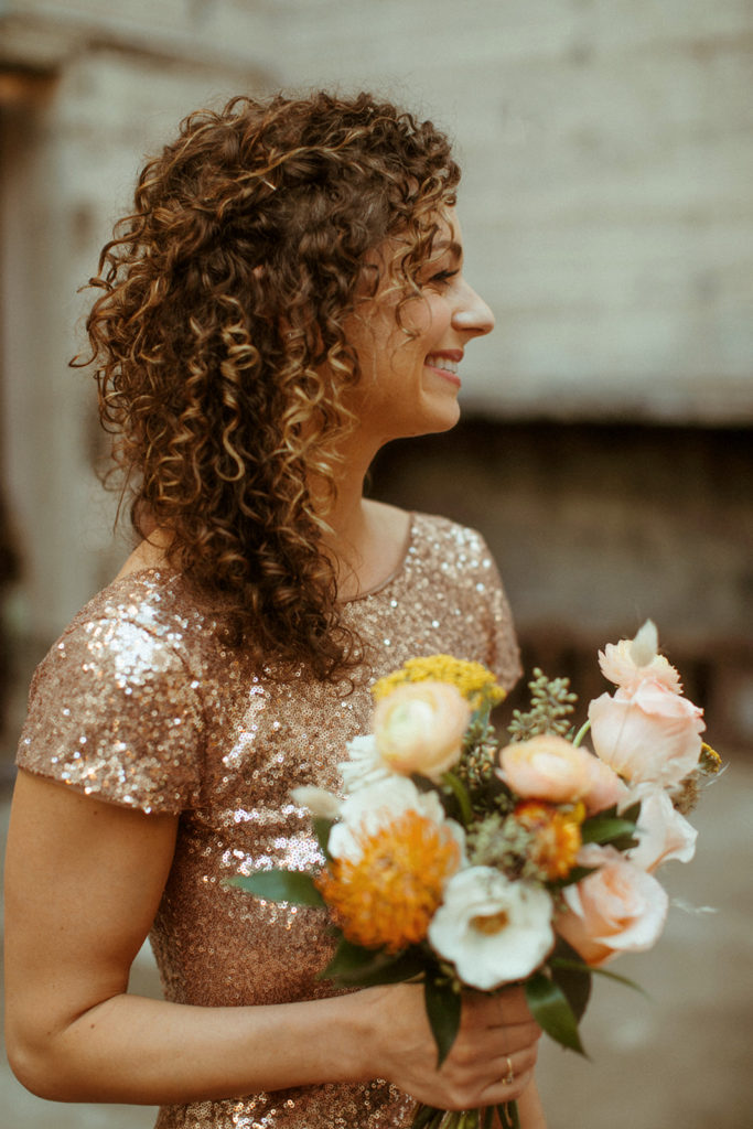 Smiling bridesmaid holding bouquet.