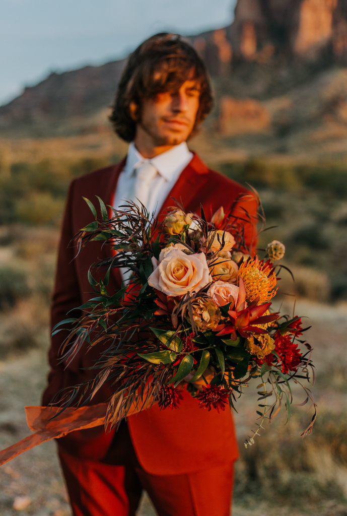 Groom holding bridal bouquet.