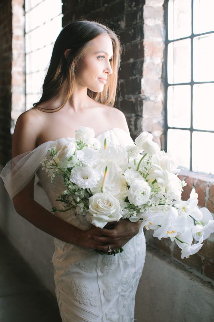 bride-looking-out-window-with-bouquet
