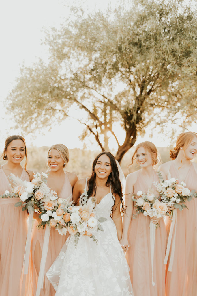 Bride walking and laughing with bridesmaids.