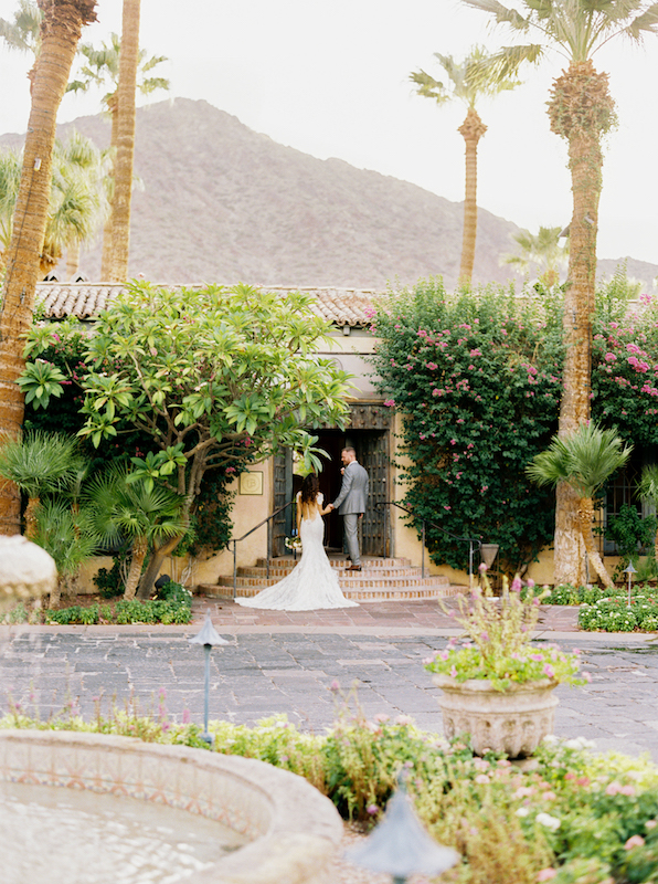 Bride and groom walking up stairs of Royal Palms in Phoenix.