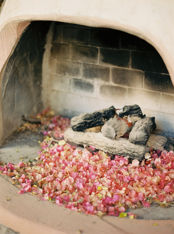 Outdoor fireplace with bougainvillea leaves in it.