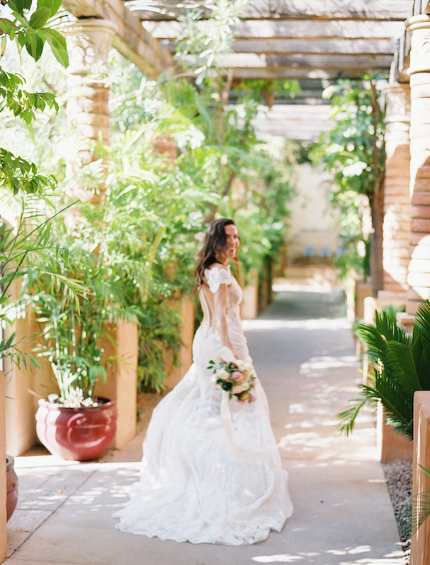 Bride walking down covered walkway at Royal Palms.
