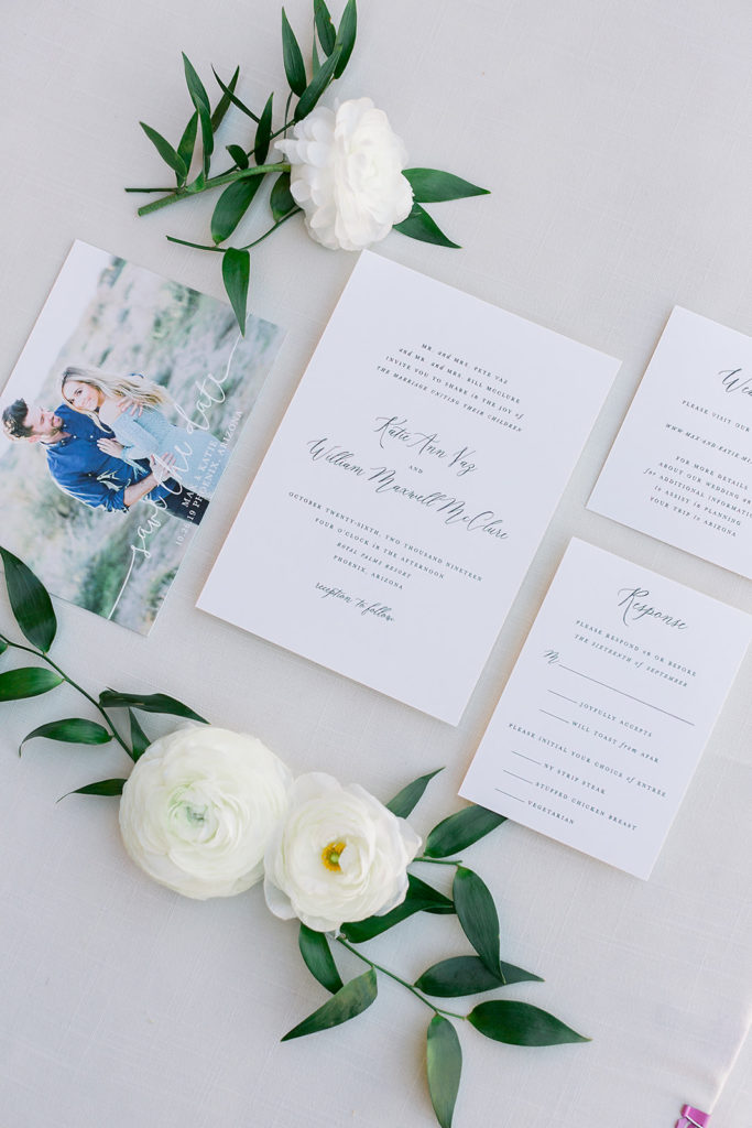 White wedding invitation suite with white flowers.