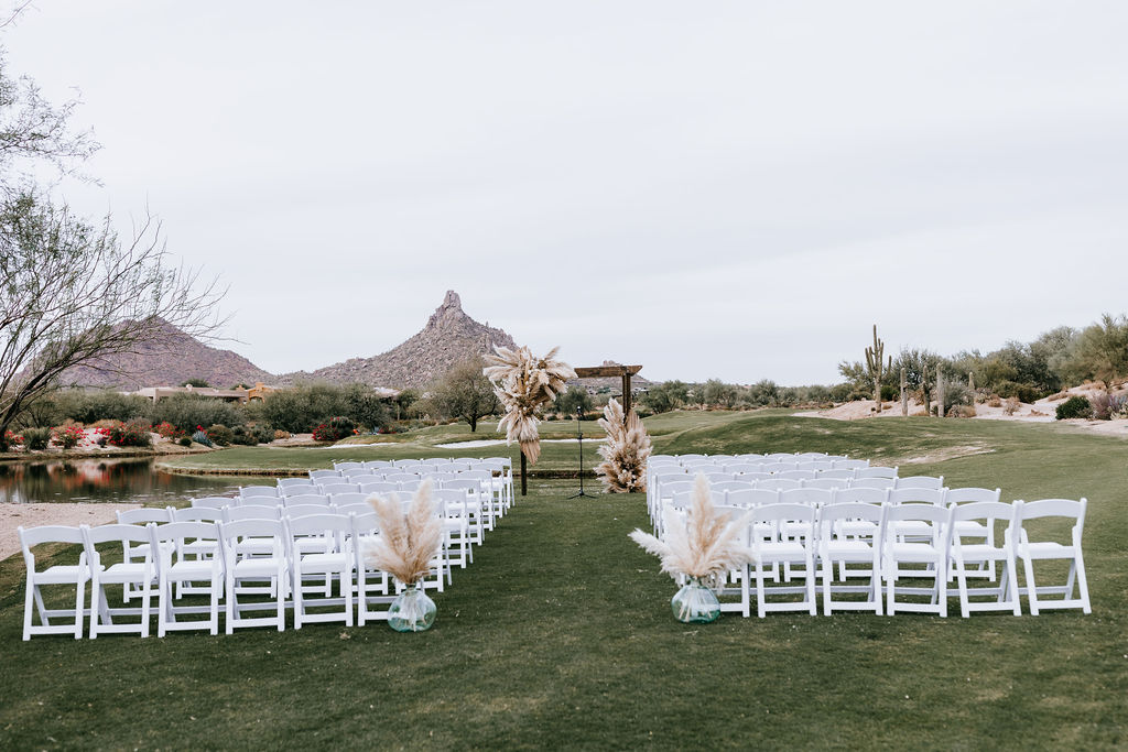 Desert backdrop outdoor wedding ceremony with boho floral.