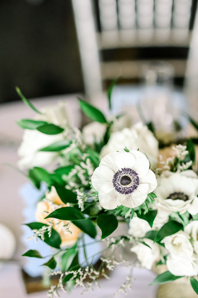 Wedding reception centerpiece in silver vase of white, pink, flowers.