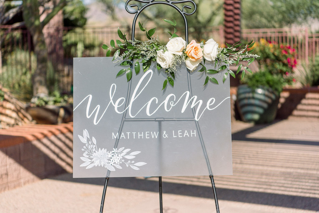 Opaque glass welcome sign with accenting floral arrangement.