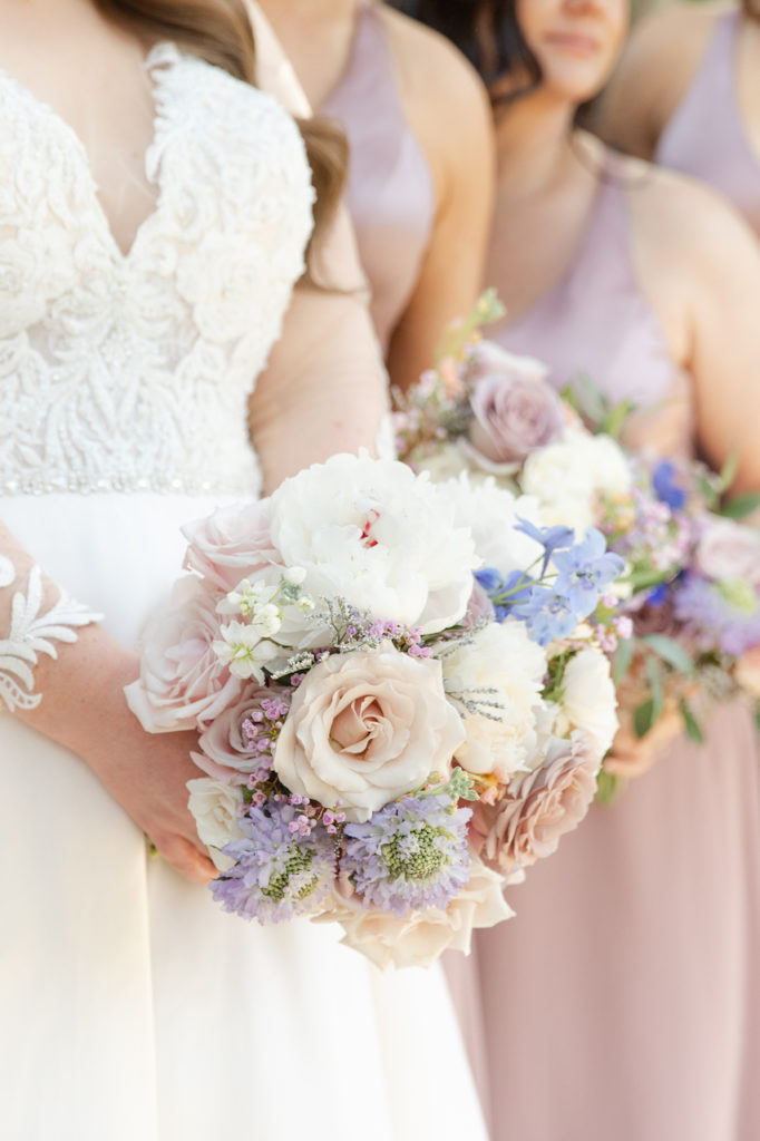 Bridal bouquet of white, pink, mauve, and blue.