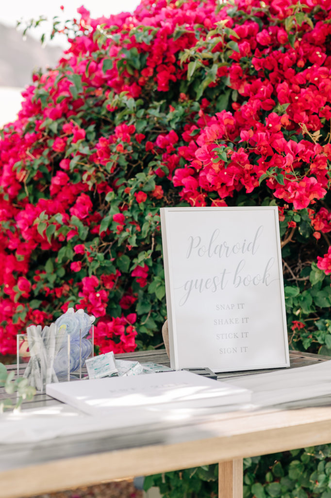 Guest books table polaroid in front of bougainvillea.