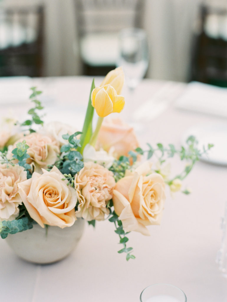 Wedding reception centerpiece with pink roses, yellow tulip.