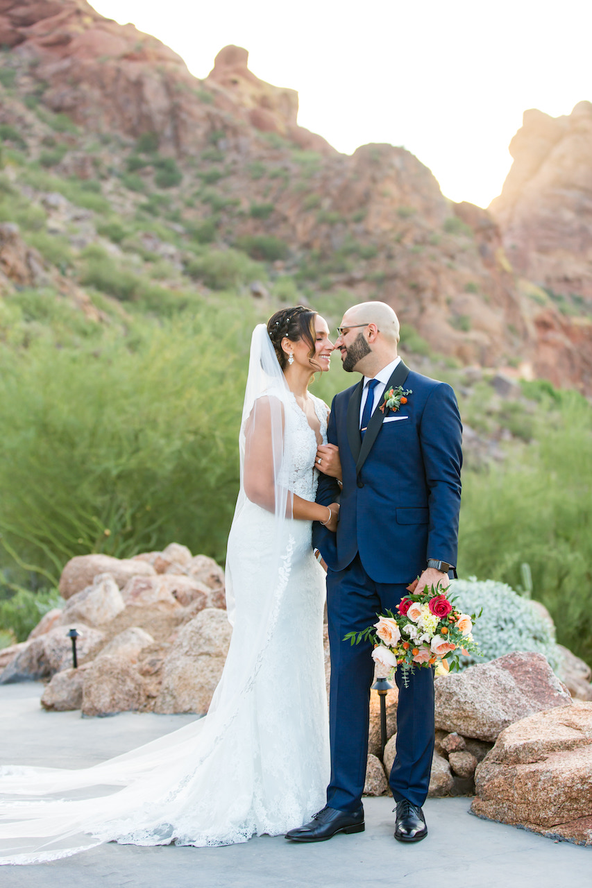 Arizona desert backdrop with bride and groom looking at each other.