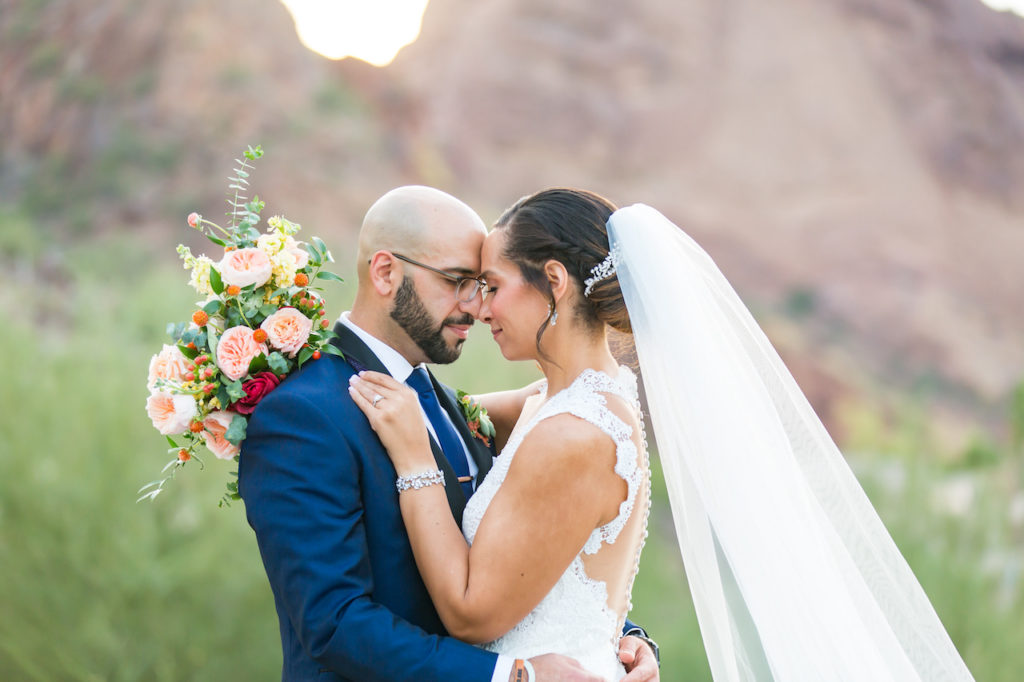 Desert mountain backdrop with bride and groom embracing.