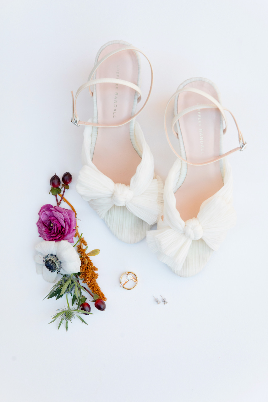 Bride's shoes, flower details, rings, and earrings.