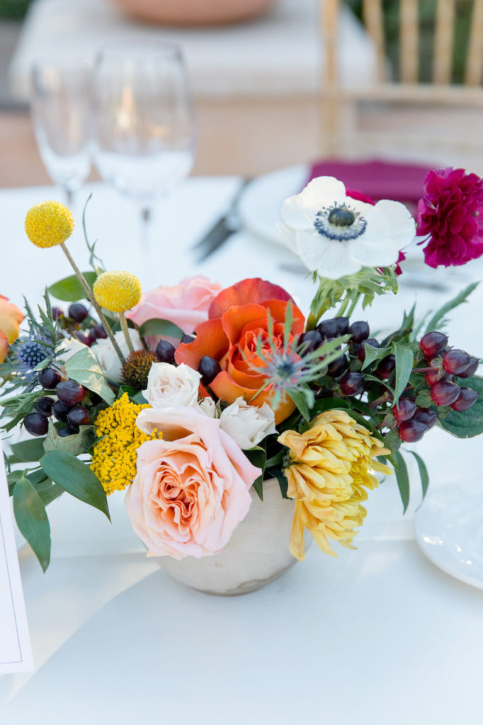 Wedding reception centerpiece in vase with colorful fall palette.