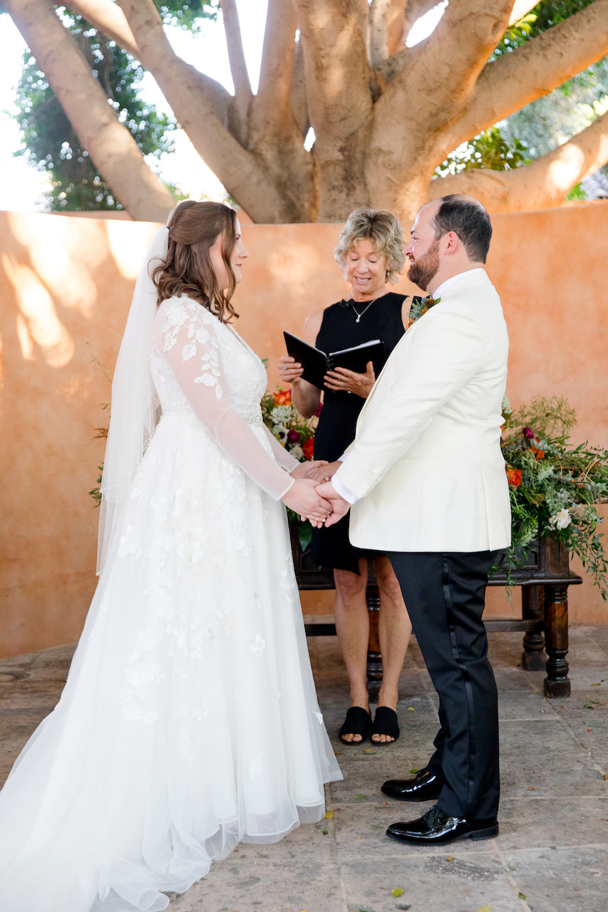 Bride and groom with officiant during wedding ceremony at Royal Palms.