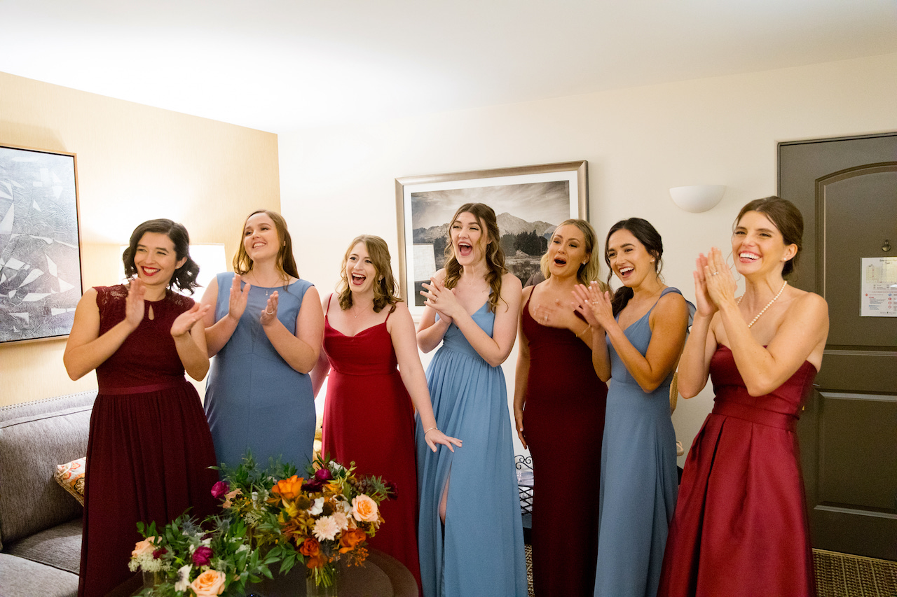 Excited bridesmaids seeing bride in dress for first time.