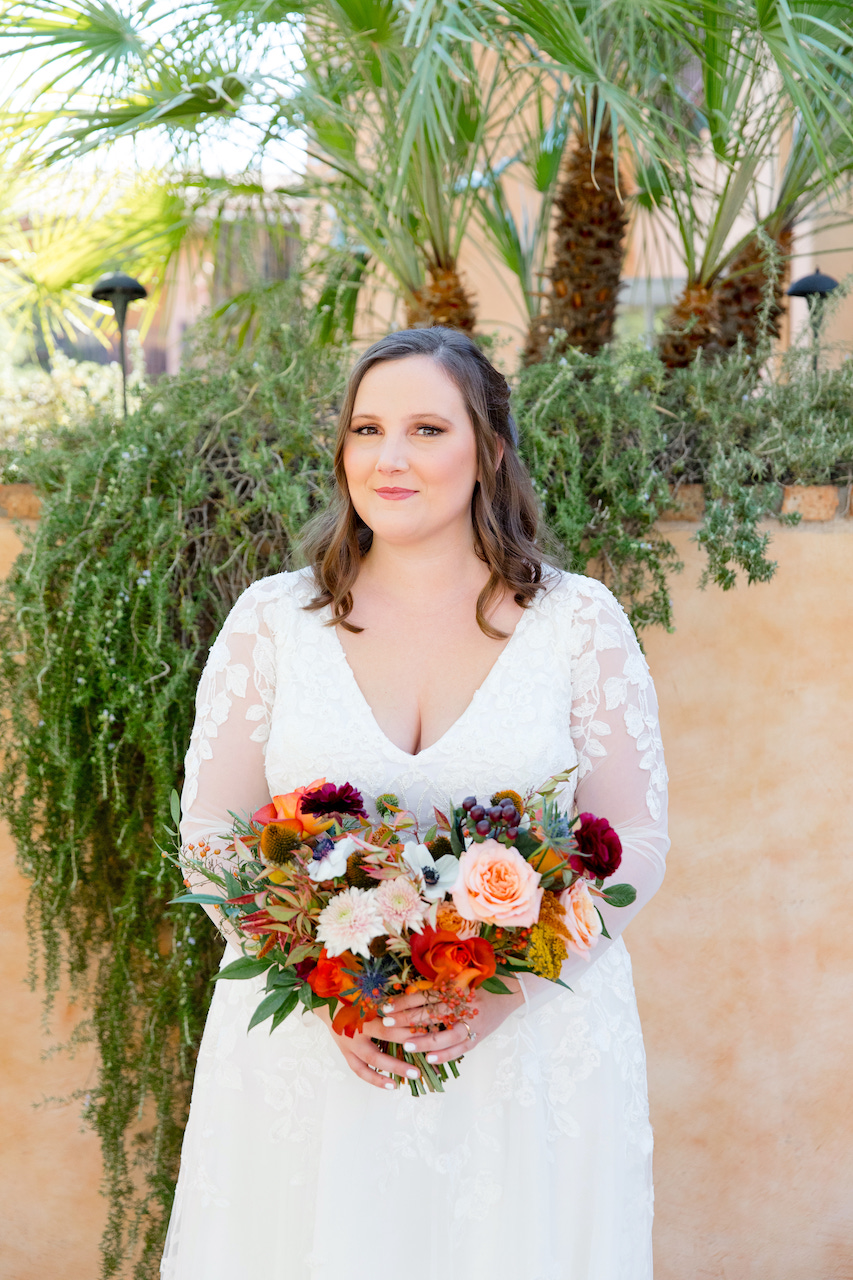 Bride with bridal bouquet of lush fall colored flowers.