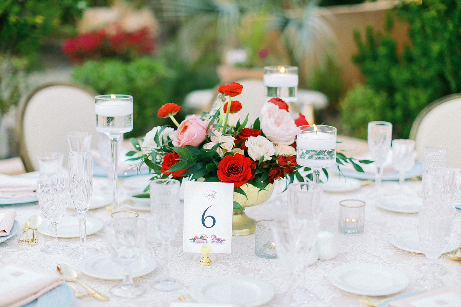 Pink, red, and white floral with greenery low wedding reception centerpiece.