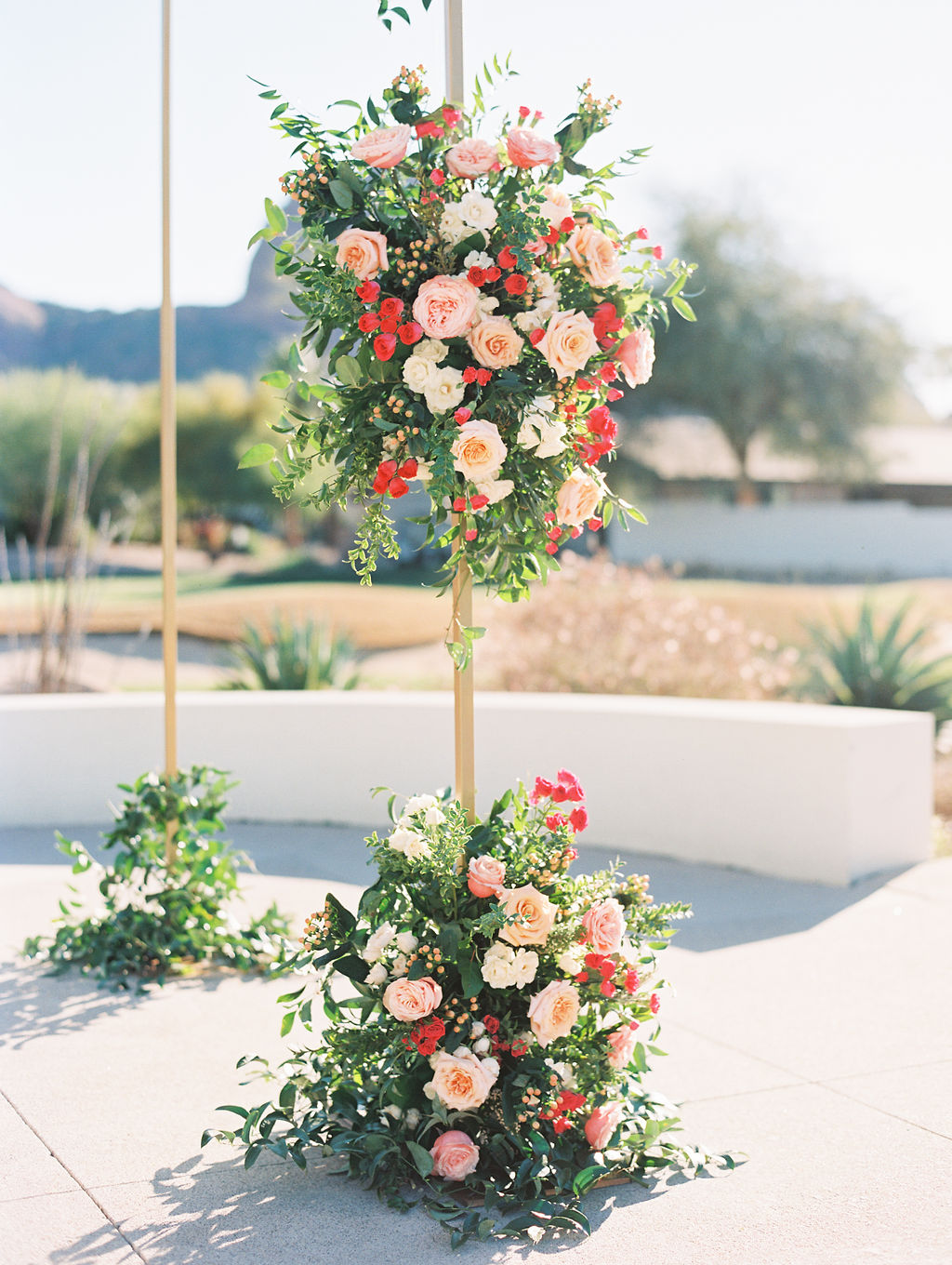Floral installation on gold wedding chuppah of pink and peach flowers.