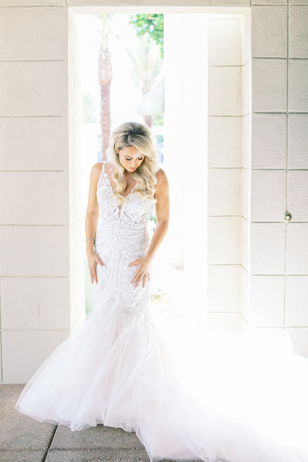 Bride and white mermaid wedding dress with trailing train.