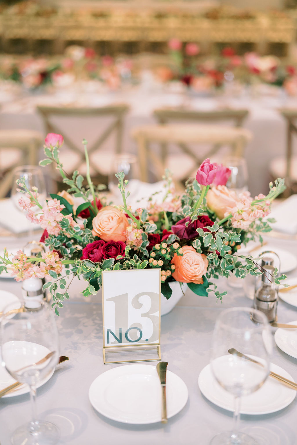 Reception centerpiece in white vase of pink and peach flowers.
