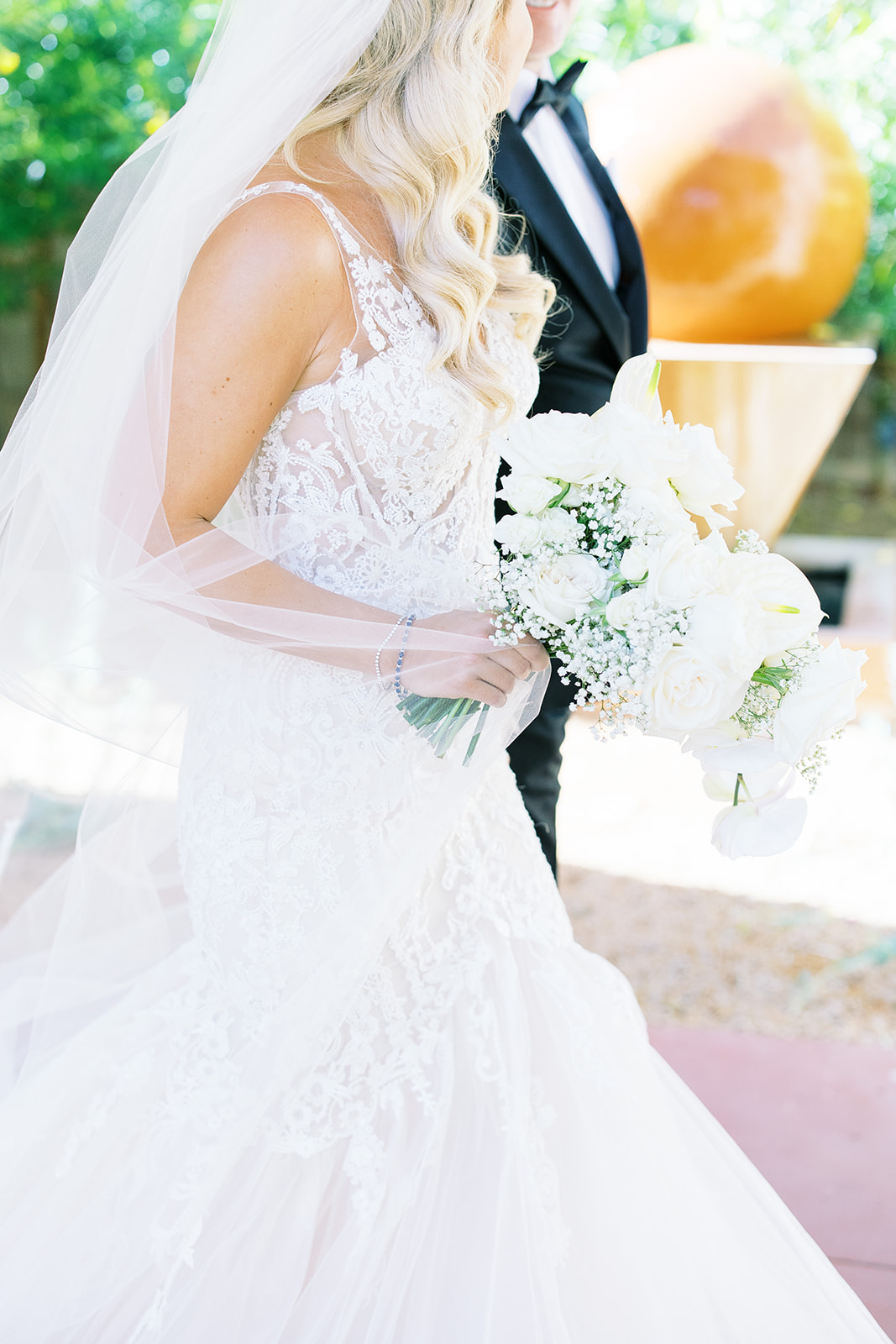 Bride holding white floral bouquet.