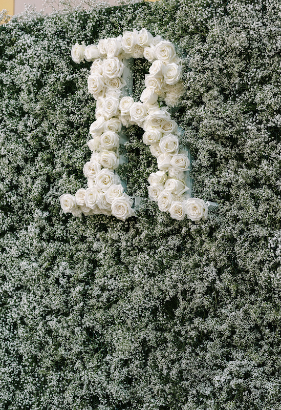 Baby's breath backdrop wall with custom letter "R" in white roses.